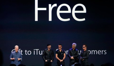 Apple CEO Tim Cook stands with Irish rock band U2 as he speaks during an Apple event announcing the iPhone 6 and the Apple Watch at the Flint Center in Cupertino