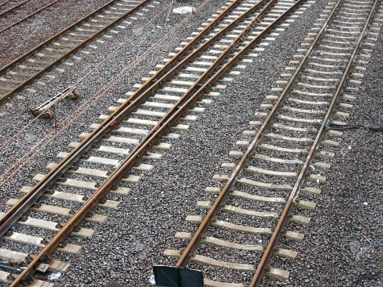 3533720-Parallel-lines-of-rusted-railway-tracks-set-in-grey-moisty-clinker--Stock-Photo