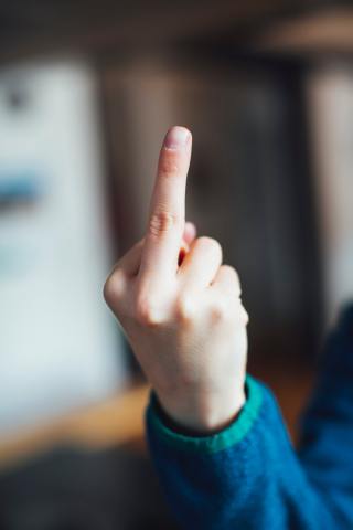 Young boy shows the middle finger – symbolic tell somebody to fuck off